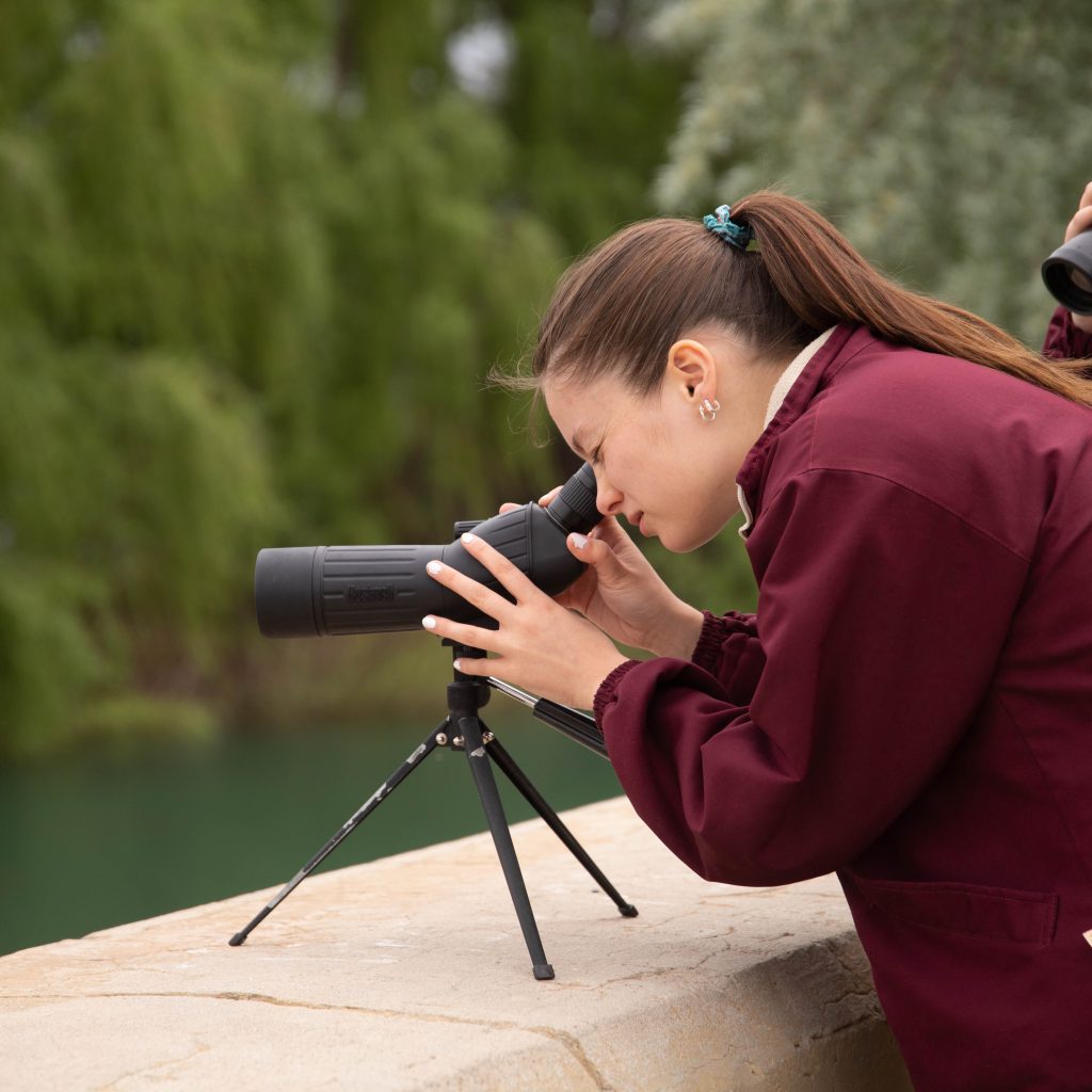 alumna mirando telescopio